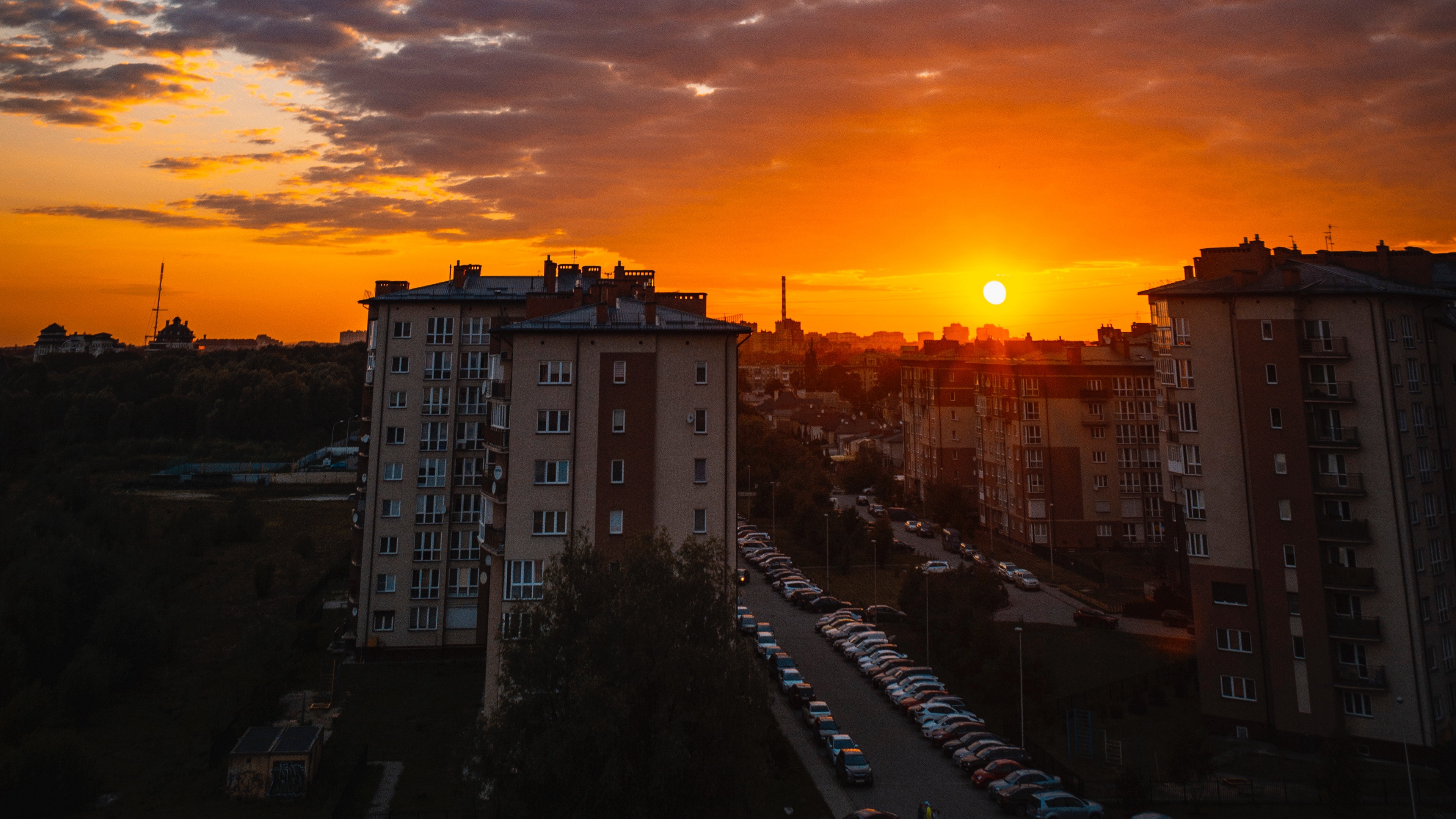 city buildings sunset clouds parking 4k 1538066682