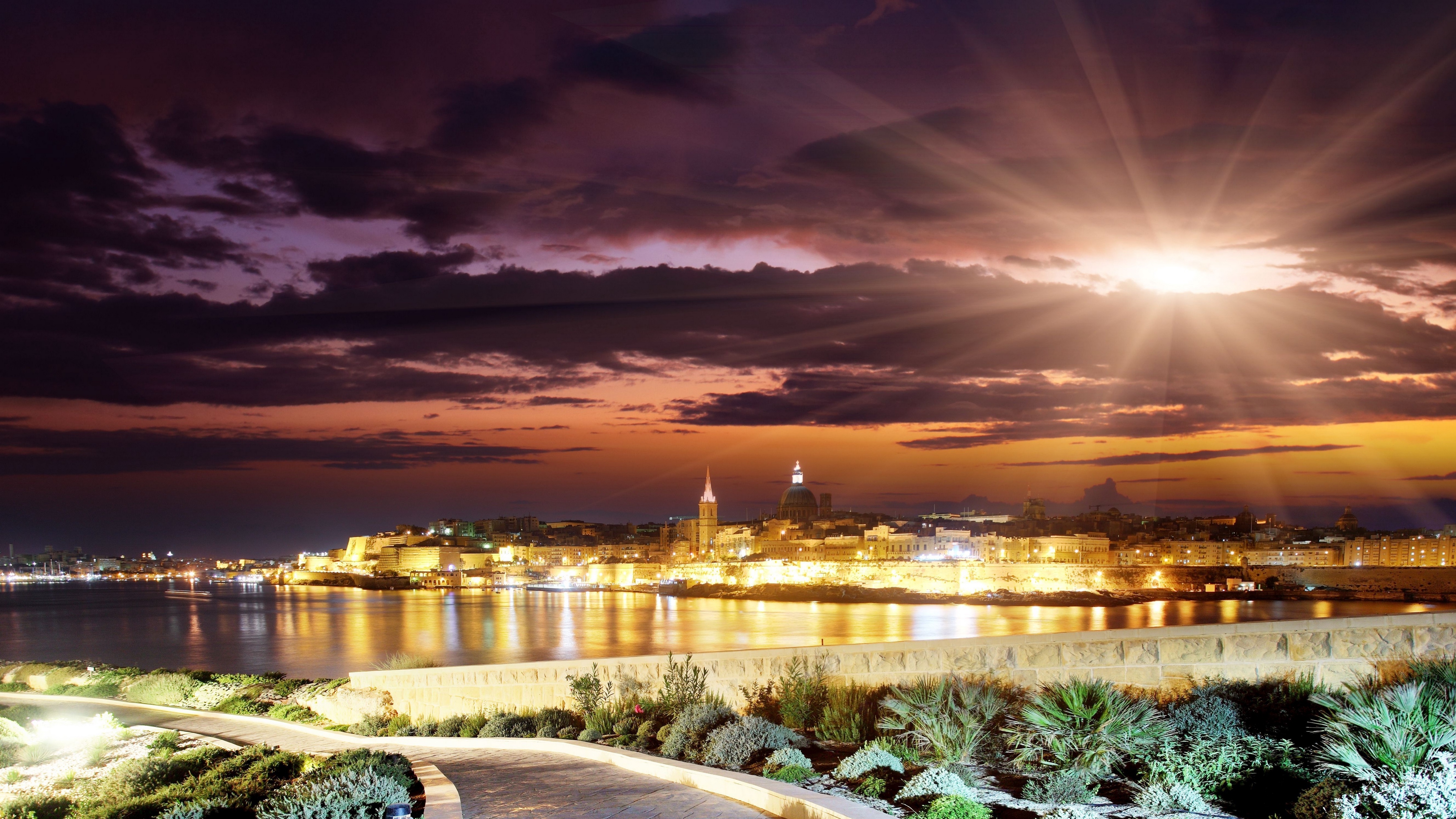 evening sunset sun clouds city landscape track buildings skyline 4k 1538067185