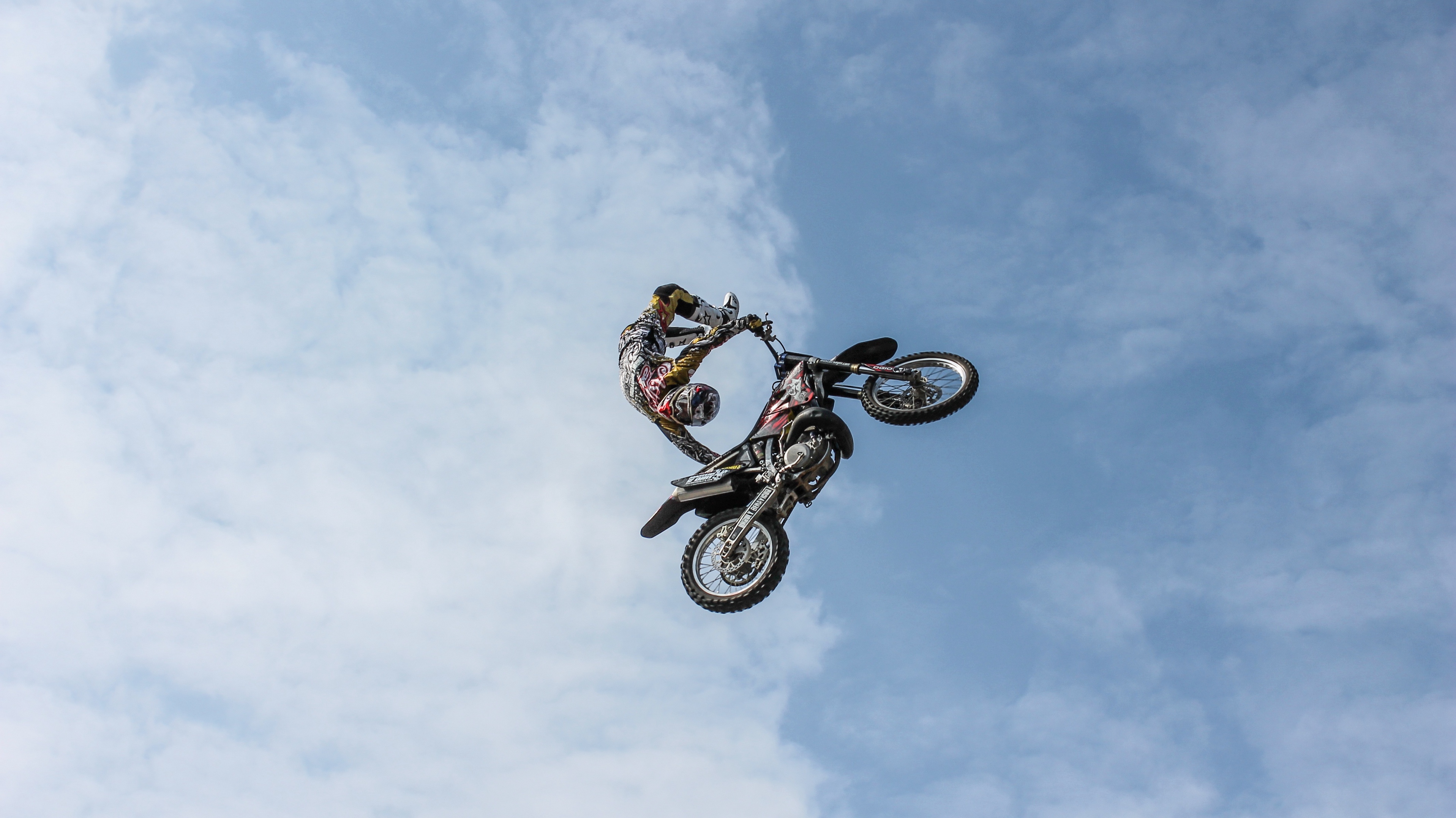 biker motorcycle extreme trick clouds sky 4k 1538943841