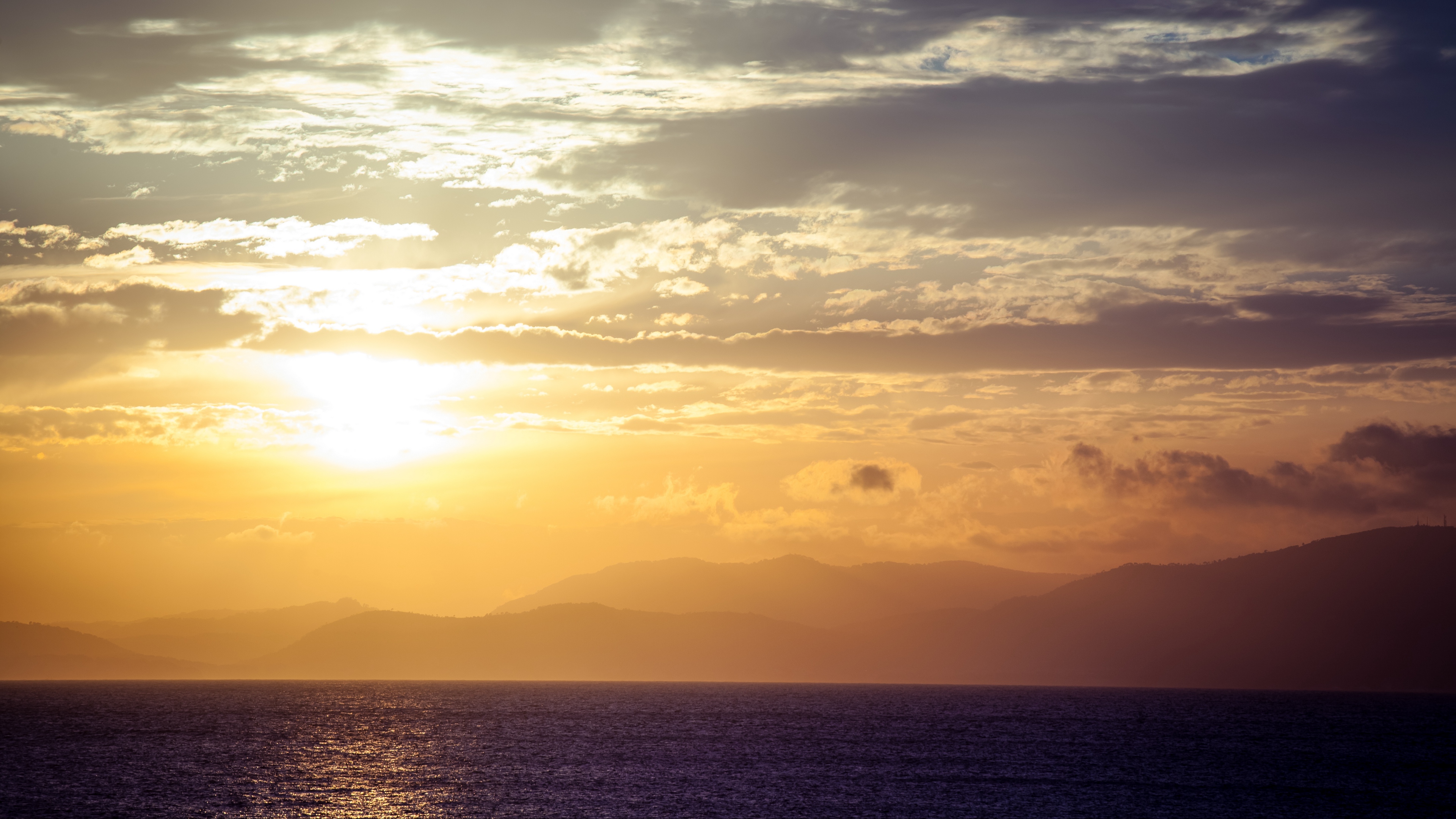 sea horizon sunset clouds mountains fog 4k 1541113744