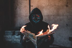 mask guy reading a burning news paper 1574938395