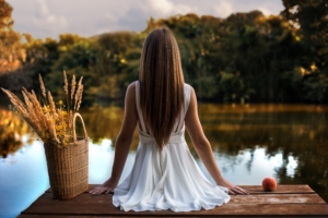 girl sitting on pier back view 1575664411