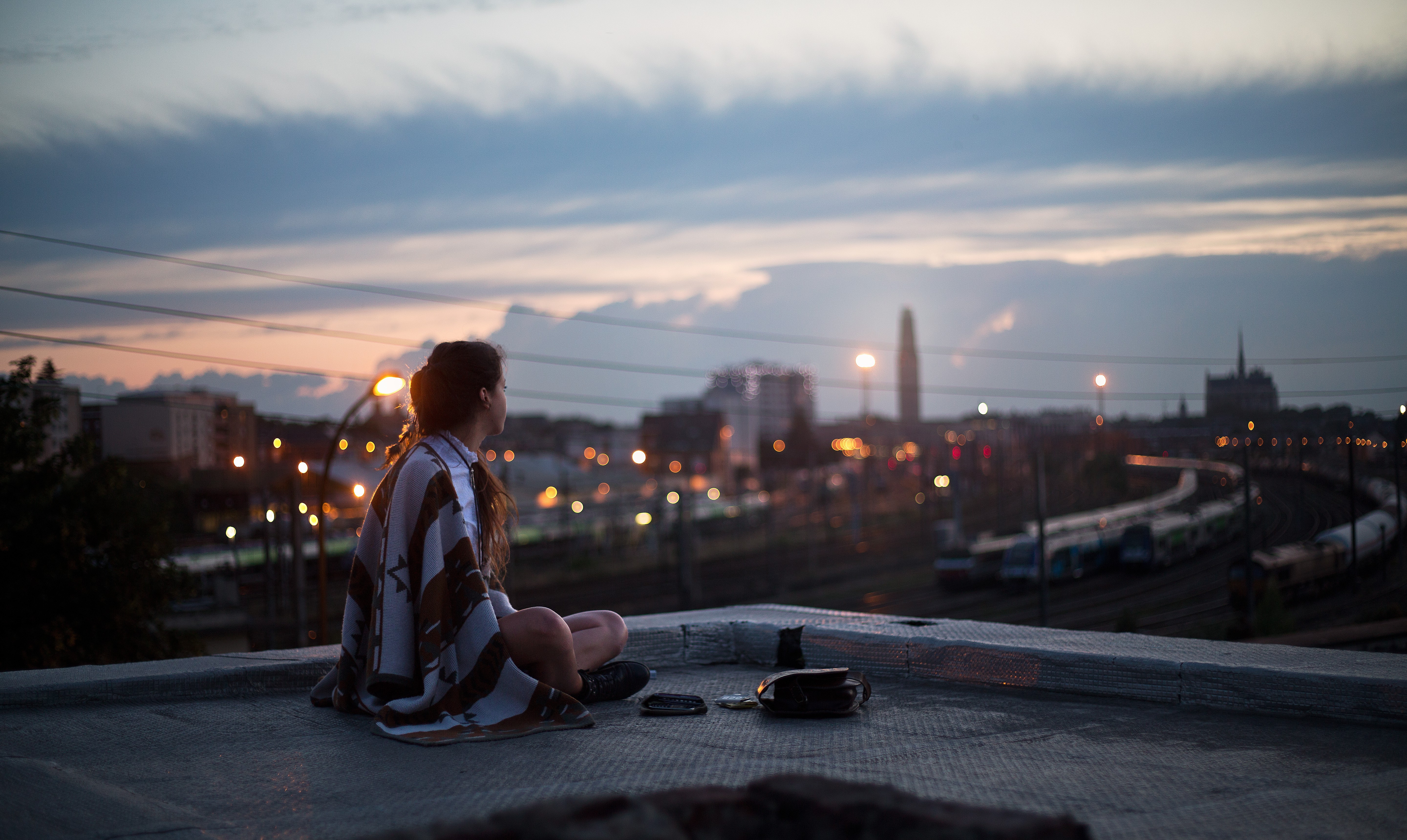 girl sitting on rooftop looking towards town 1575665237