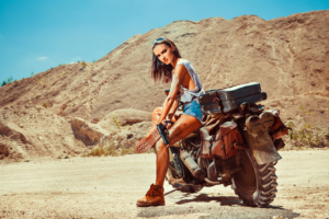 woman with gun and motobike on the desert 1575665088