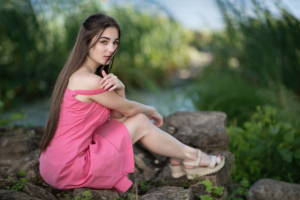 cute girl sitting on rock in pink dress looking at viewer 4k 1629241298