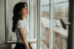 girl looking outside window 4k 1629240359