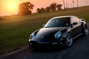 porsche 911 turbo 997 black front sun grass reflections 4k 1691828527